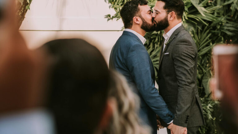 Stock image of two men kissing in a wedding ceremony