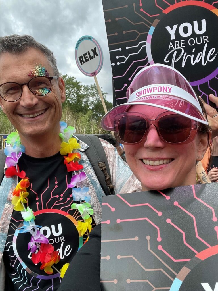 Two people smile into the camera at Pride in London