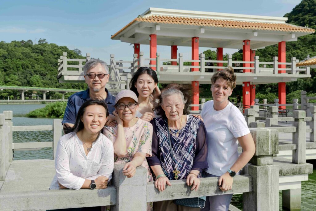 A group of people stand in front of a Taiwanese monument smiling