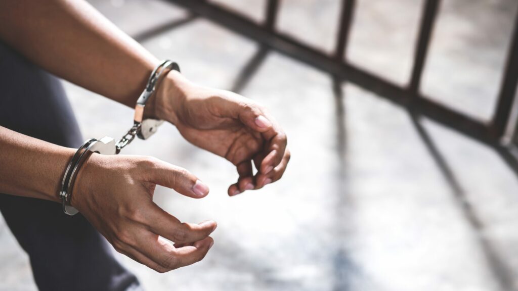 Stock photo of a close up of a man's hands in handcuffs