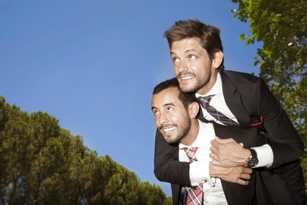 Two men in suits, one is giving the other a piggy back ride