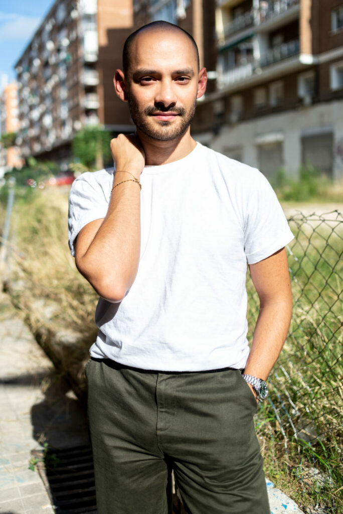 Jose C M standing by a fence in a t-shirt and trousers (Image: Elska)