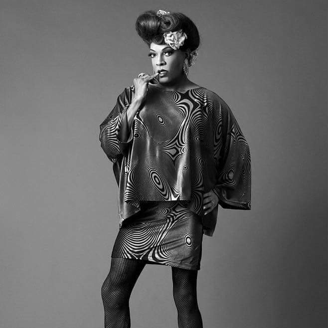 Black and white image of a drag queen wearing a Pucci style dress