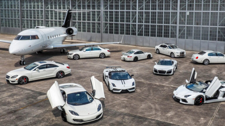 A selection of vehicles sits on an airport hangar