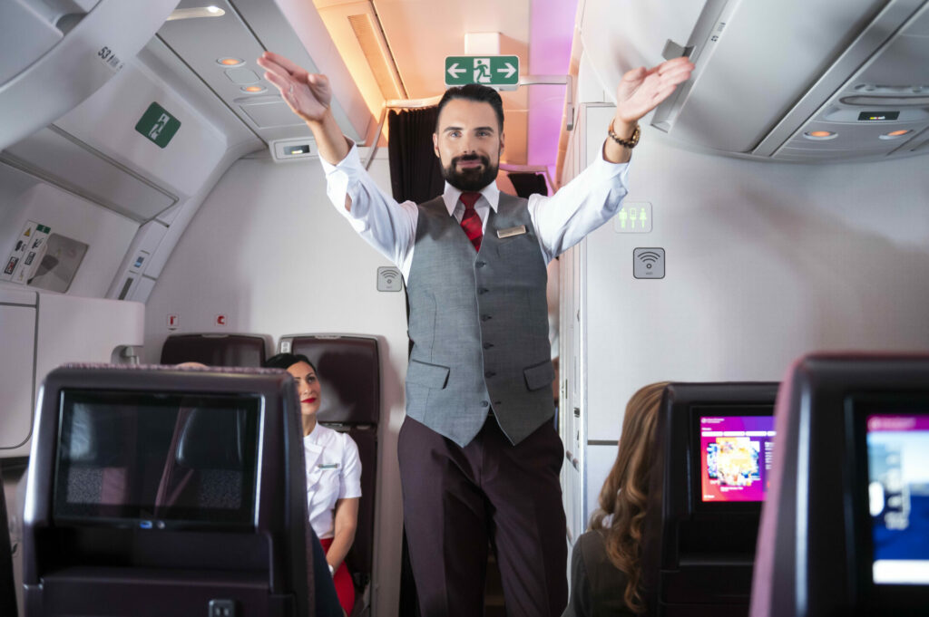 Rylan Clarke points out the emergency exits to passengers 