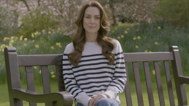 Kate Middleton sat on a bench in a garden