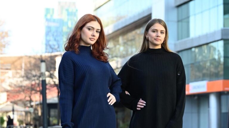 Two people standing before a shiny, modern building (Image: Provided)