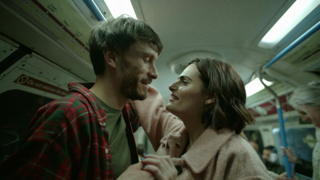 Still from Baby Reindeer showing Donny and Teri standing on a train together
