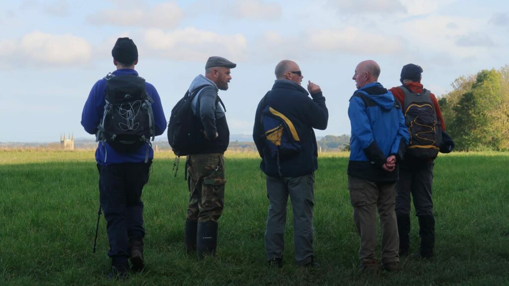 A group of men walk in the countryside