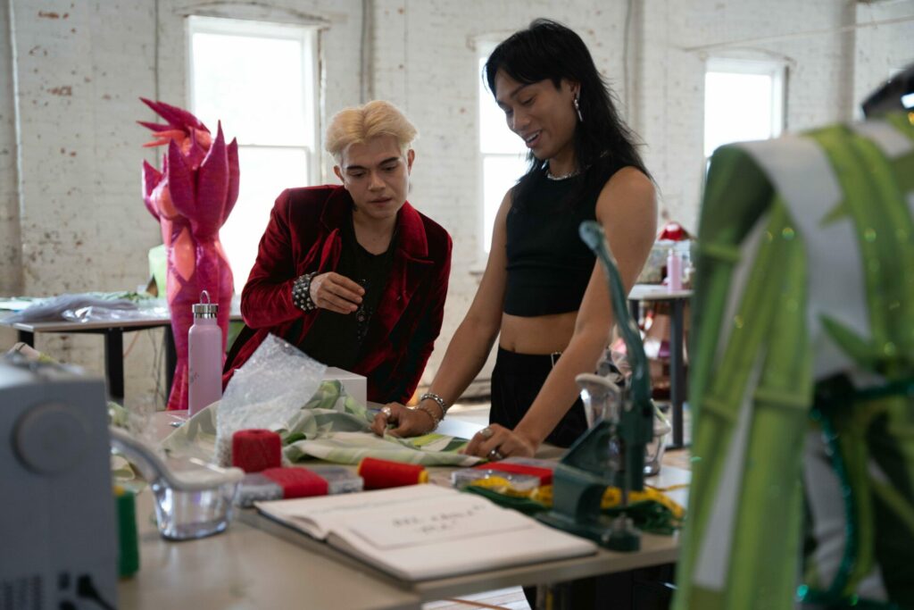 Two people chat over a fashion work station