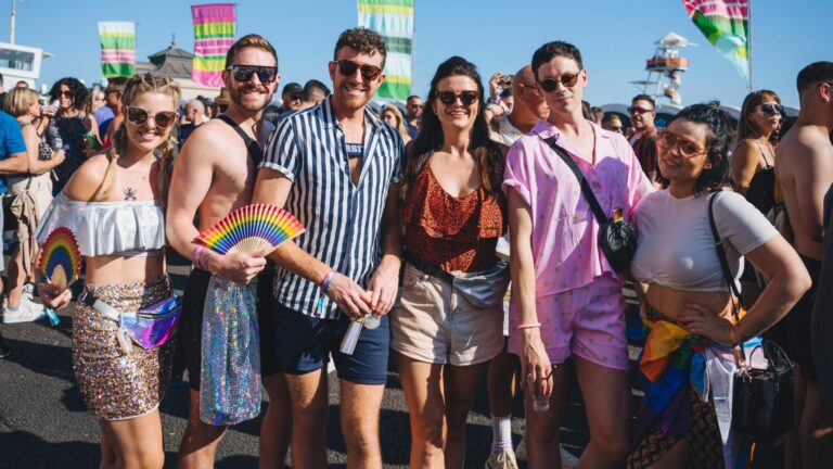 A group of smiling people standing in the street in Brighton at Pride