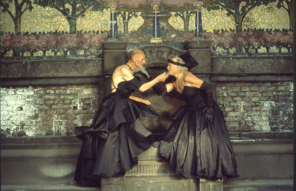 Two older, bearded people in dresses