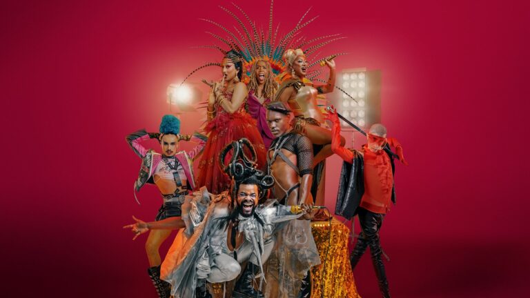 Group shot of drag performers against a red backdrop