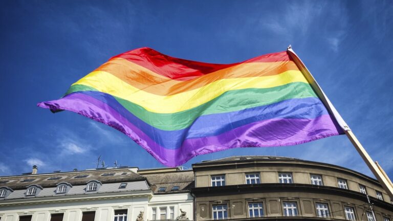 A pride flag blowing in the wind