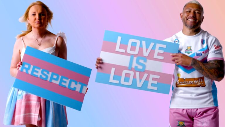 India Willoughby holding a sign saying Respect standing next to a rugby player holding a sign saying Love is Love