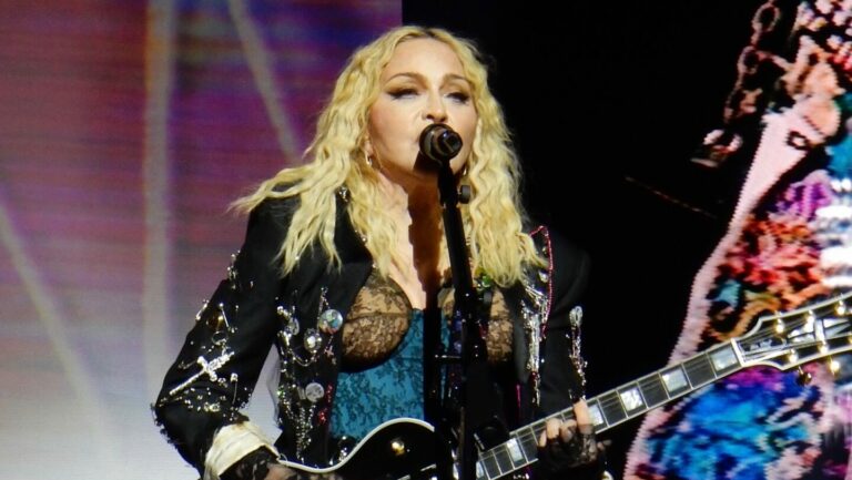 Madonna on stage holding a guitar