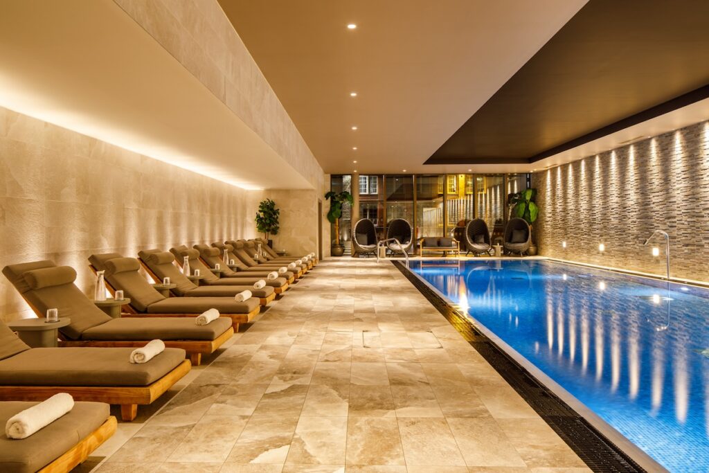 Municipal Thermae Spa, with oatmeal coloured loungers, and bright blue pool