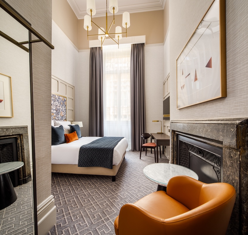 a hotel room with a bed and a chair in shot