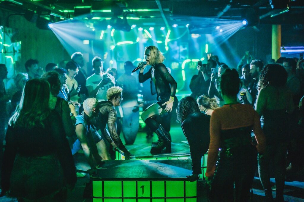a singer performing on a stage surrounded by dancers