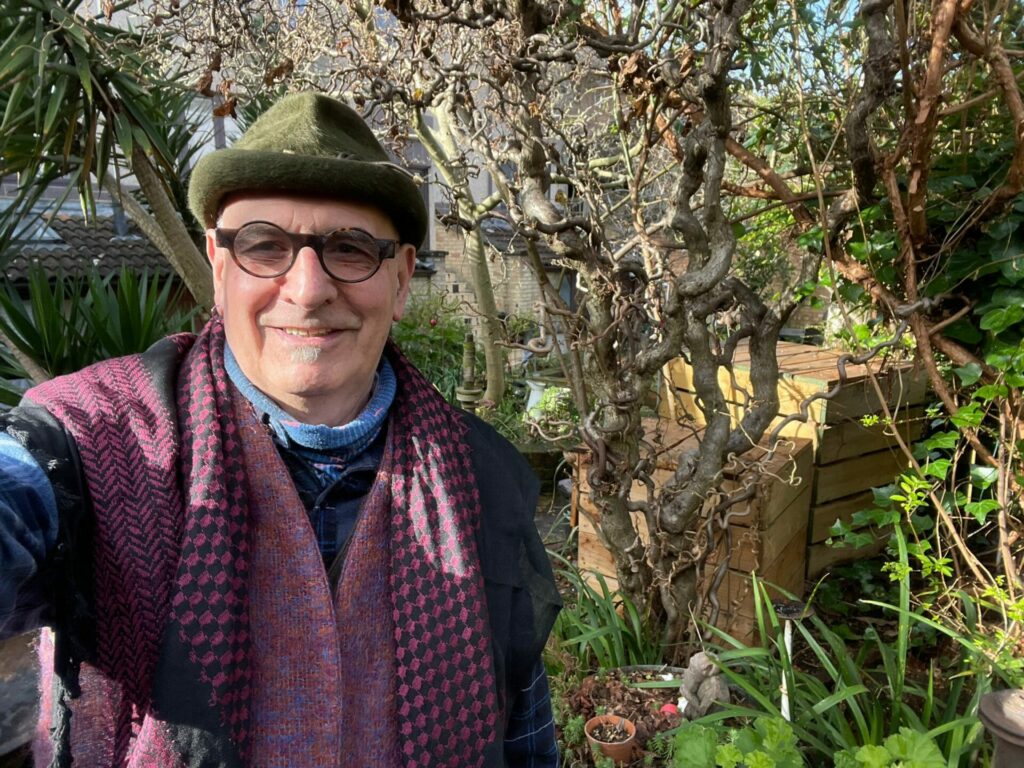 Jonathan Blake in a garden smiling into the camera