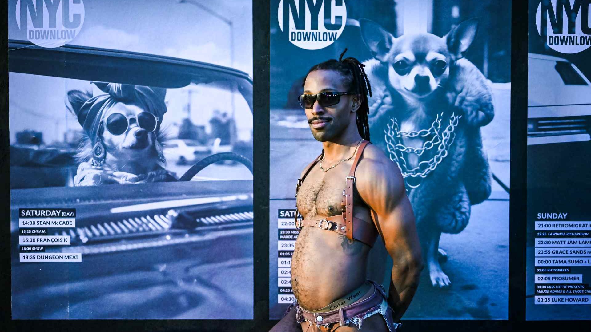 A man standing in front of a NYC Downlow poster
