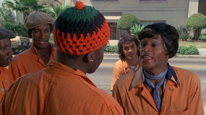 people in hats and orange overalls talking