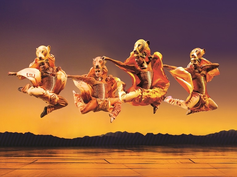 three dancers in lion costumes jumping