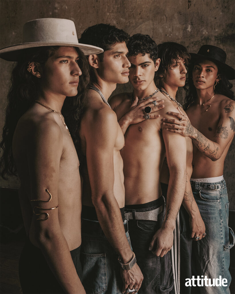 Five models topless in jeans and layered necklaces lean against one another