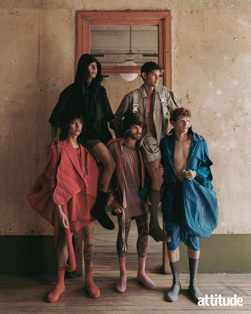 3 models stand, carrying two models on top of them wearing oversized jacket and shorts in bold colours