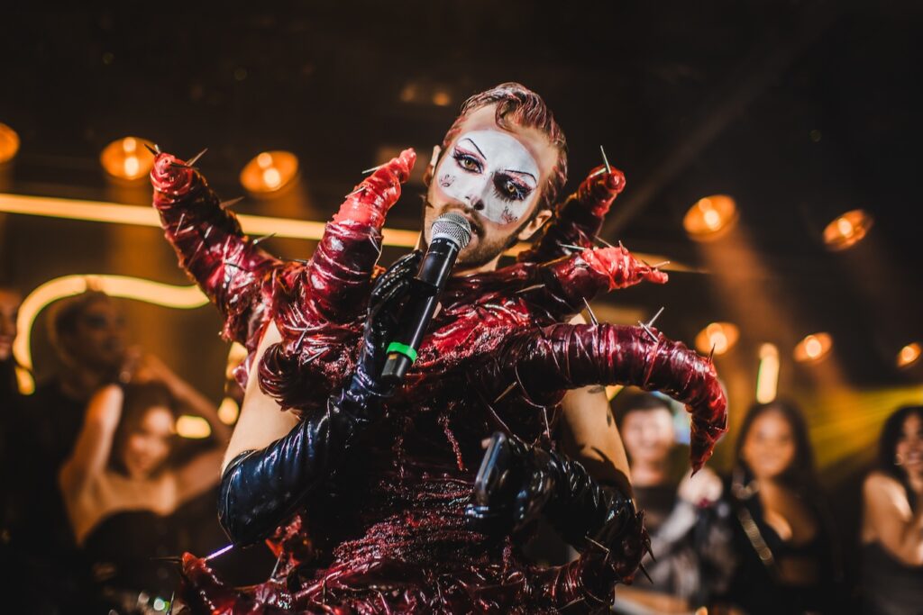 a performer singing in make-up and a tentacle-like costume