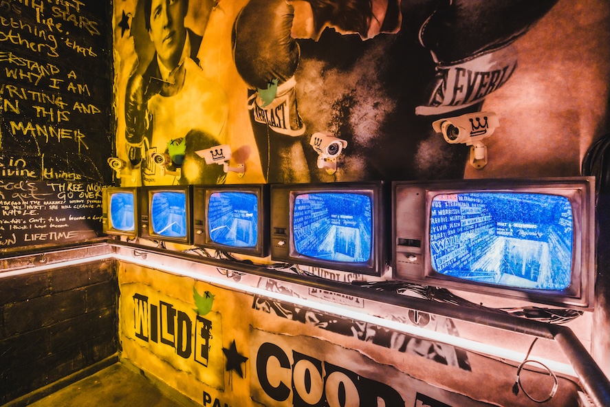 four tv screens against Oscar-themed wallpaper