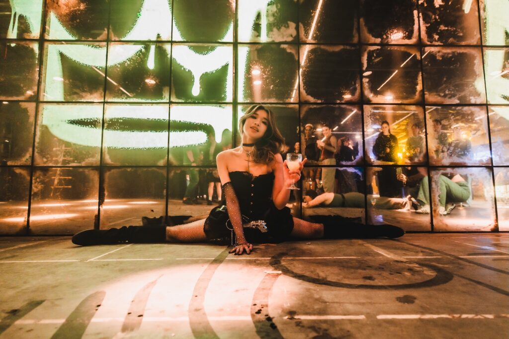 a dancer does the splits before a mirrored backdrop