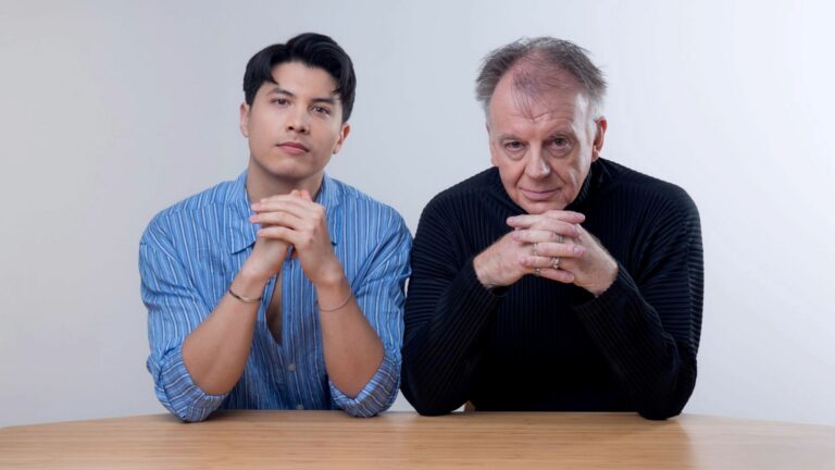 James Phoon and Paul Clayton sitting at a desk together looking into the camera