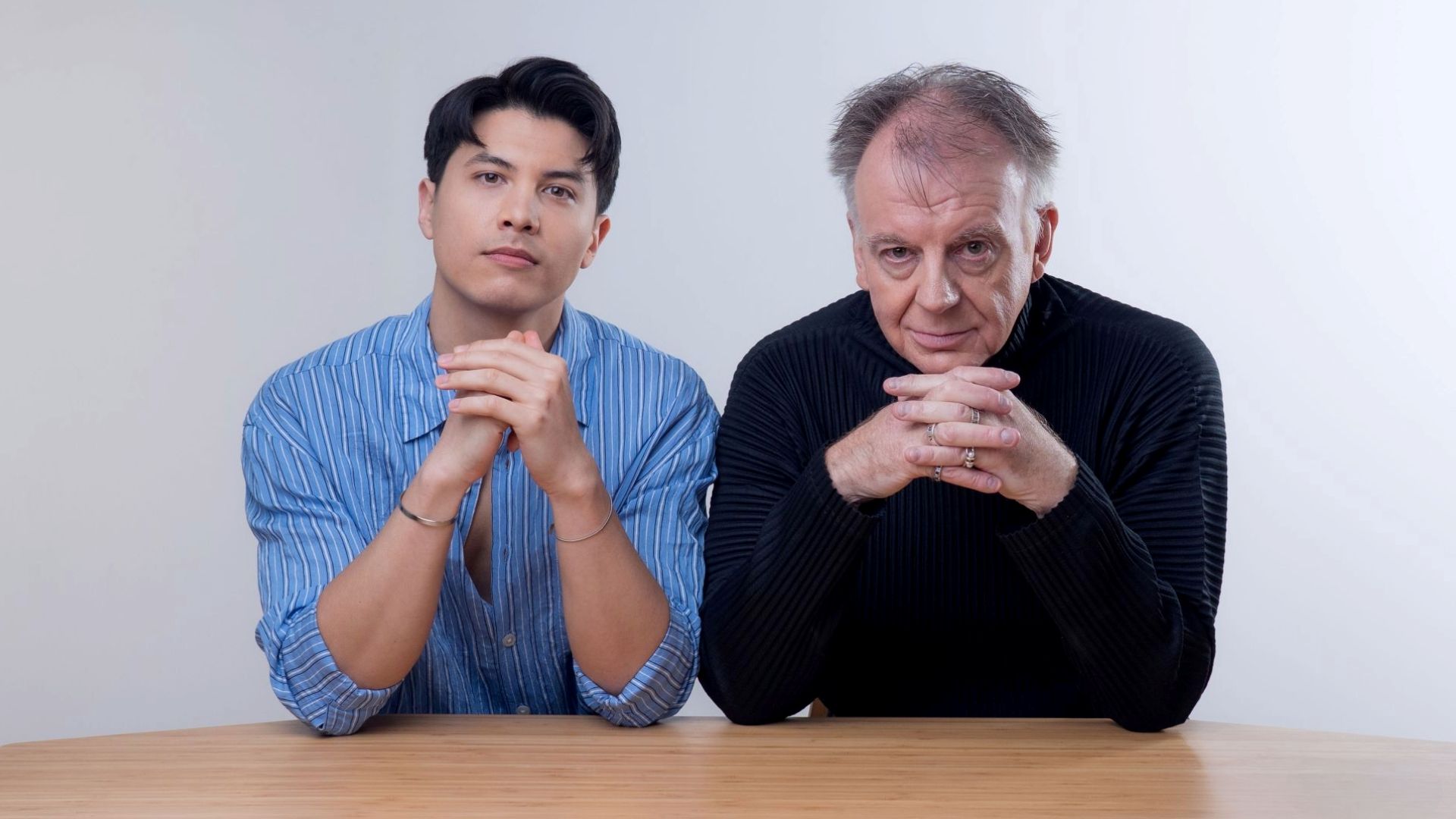 James Phoon and Paul Clayton sitting at a desk together looking into the camera