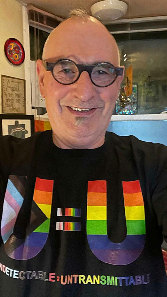 Jonathan Blake wearing a U=U T-shirt and smiling into the camera