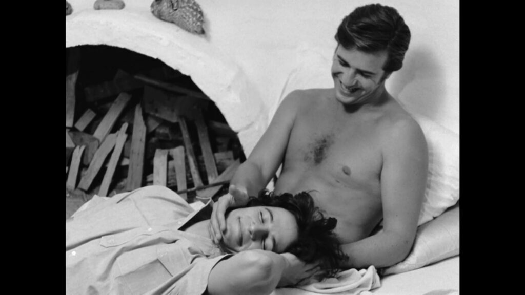 two men being affectionate, one topless, black and white