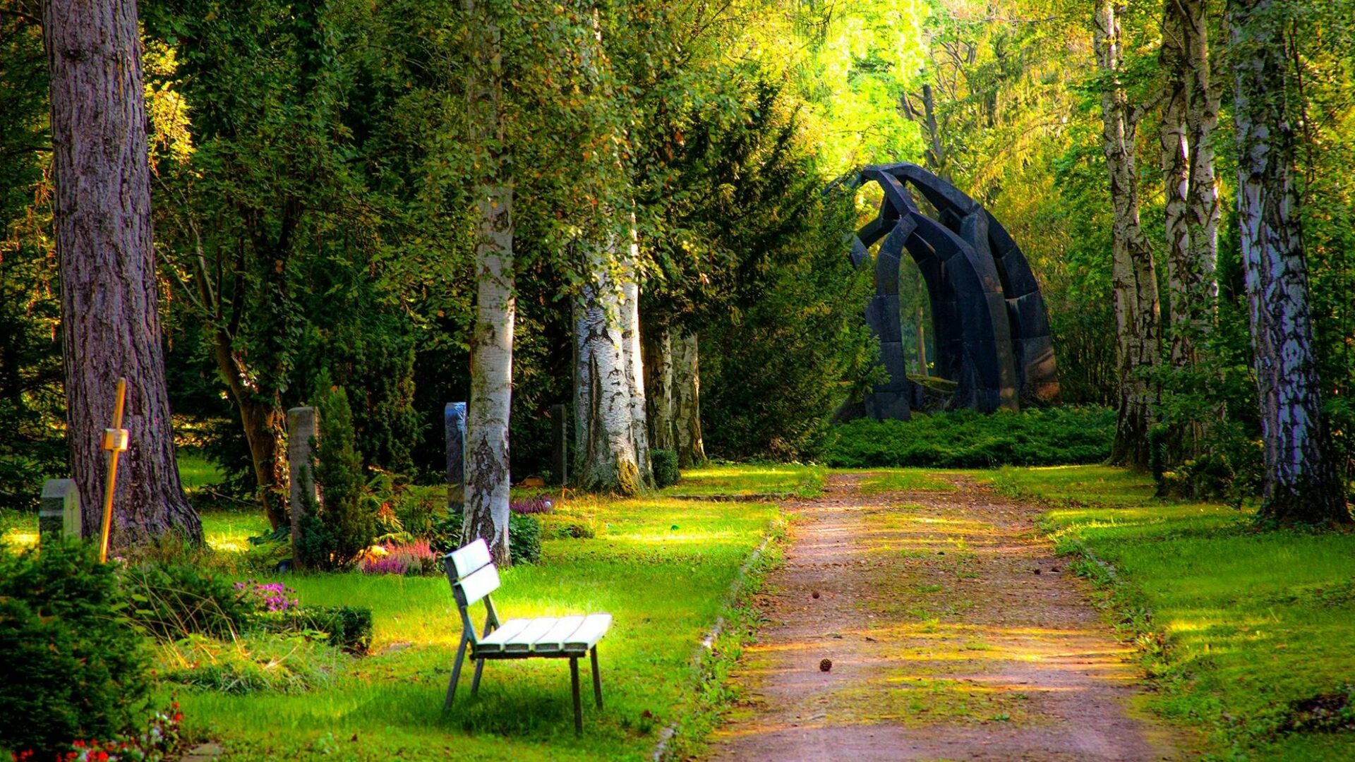 A graveyard with green grass and trees