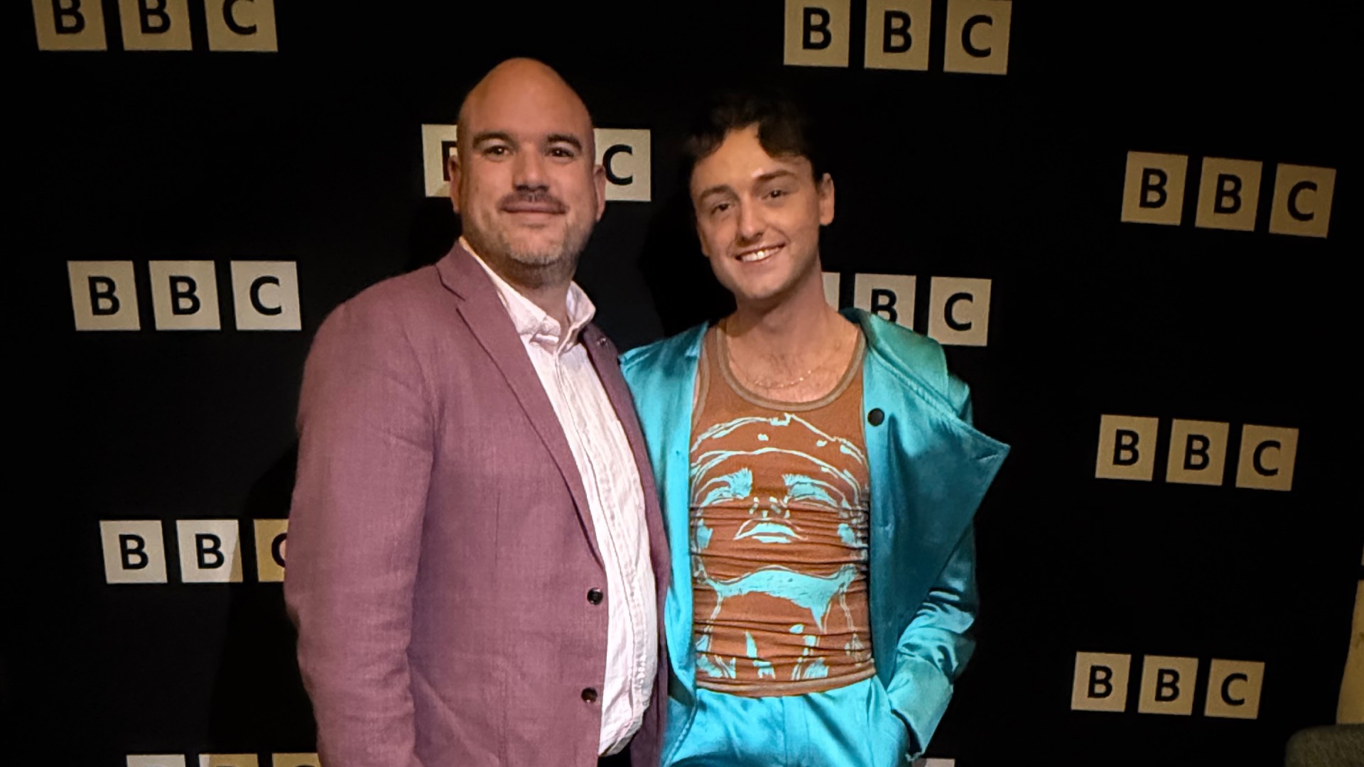 Richard Angell OBE and I Kissed a Boy's Adam posing infant of BBC branding board