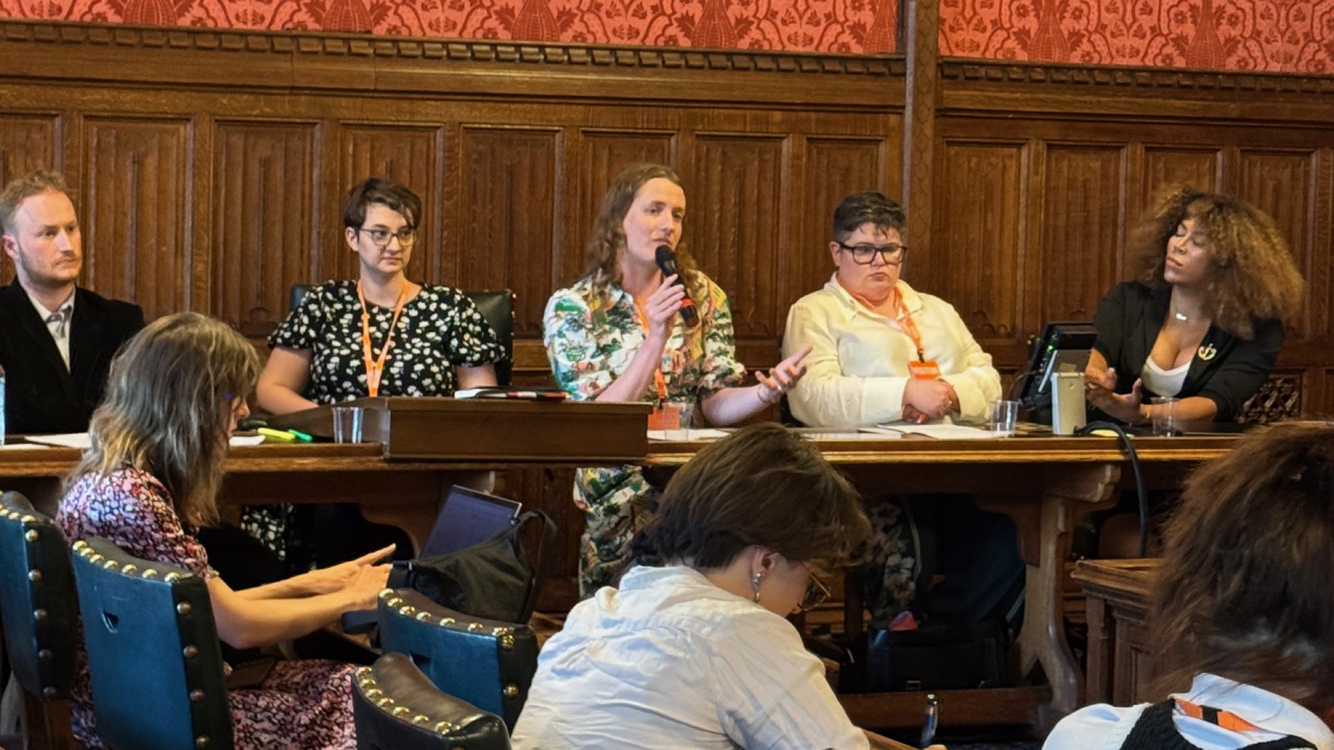 Speakers at yesterday's briefing in Parliament sitting before wooden panelling