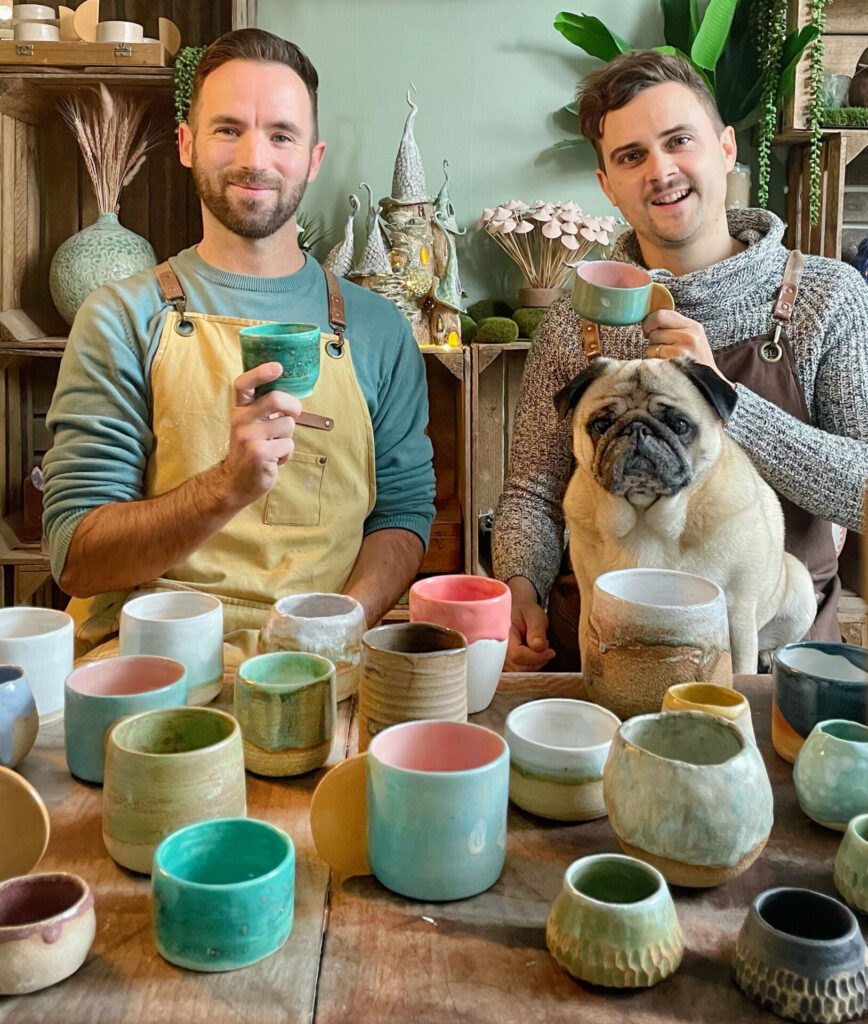 Adam Johnson and Dan Mackey with Egg, the pug, on his lap