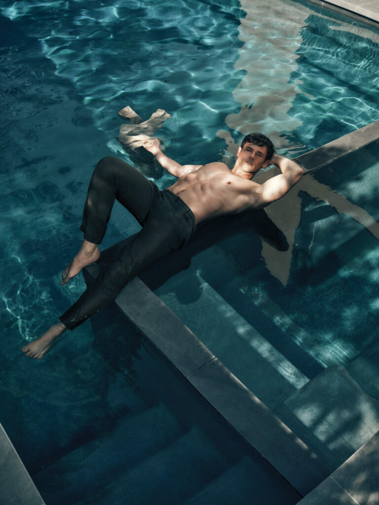 Tom Daley lies down in topless in pool with smart tailored trousers