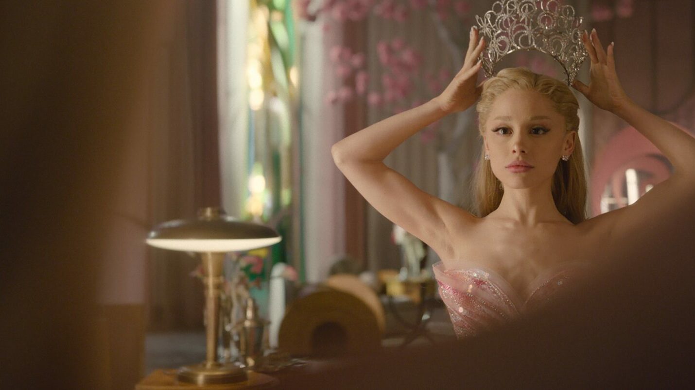 ari in costume trying on a crown