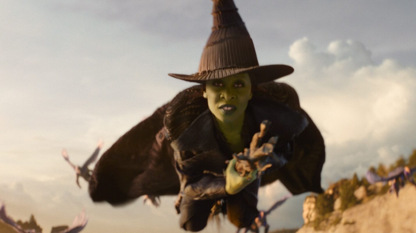 Cynthia in costume flying on broomstick