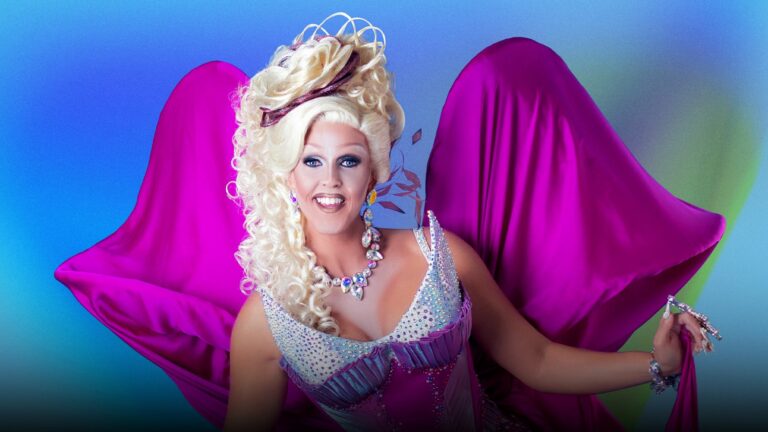 Drag queen Tess Tickle wearing a purple dress with wings against a colourful gradient backdrop
