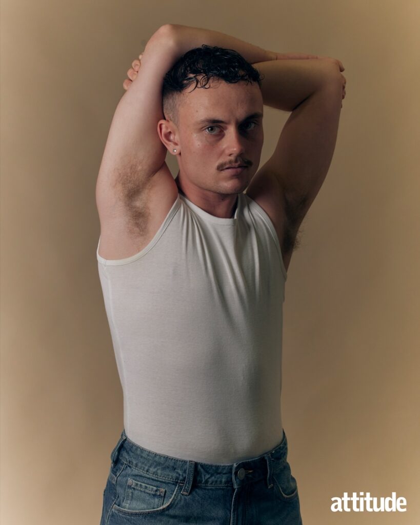 Lars in white vest with hands behind head