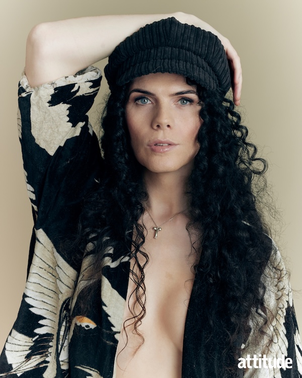 Jordan Gray in a black hat and open black and white top