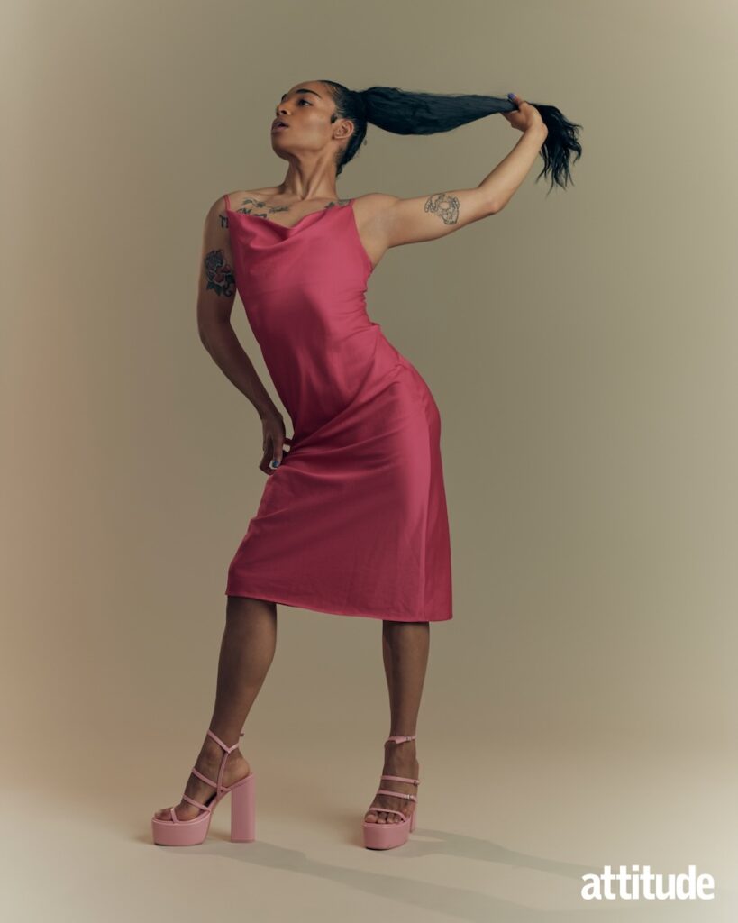 Alex in a pink dress holding hair up