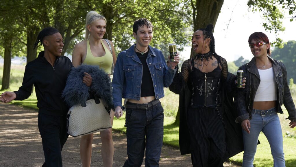 the cast walking together, five people, in a park
