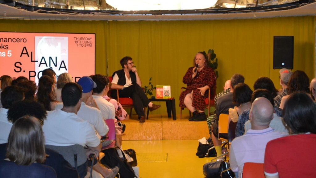 Alana S. Portero and Jorge Garriz sat down on red chairs on stage at Second Home, at the Romancero Books Fifth Anniversary event, celebrating the launch of the paperback edition of Bad Habit