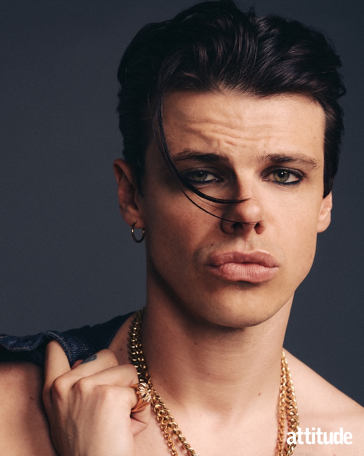 head and shoulders shot of Yungblud in a gold chain holding jacket over shoulder